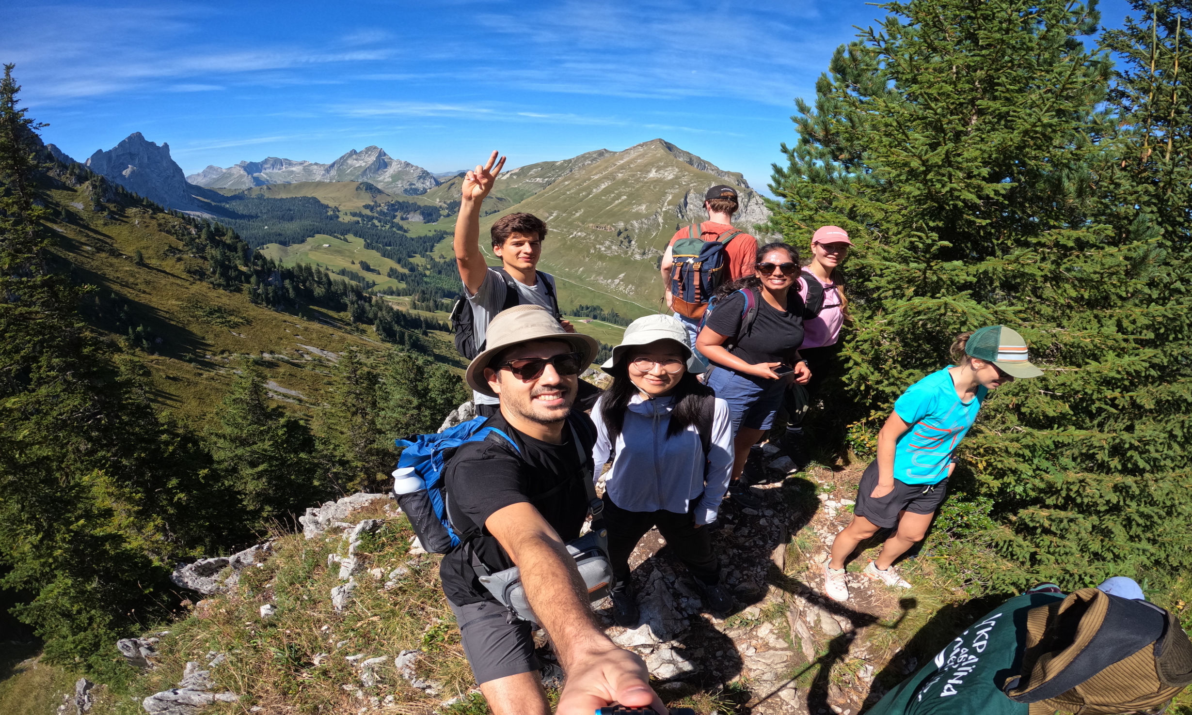 group members on a mountain sunny sky